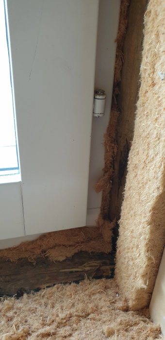 Fönsterhörn där smygen inte når fram till karmen med synlig isolering och väggstruktur.