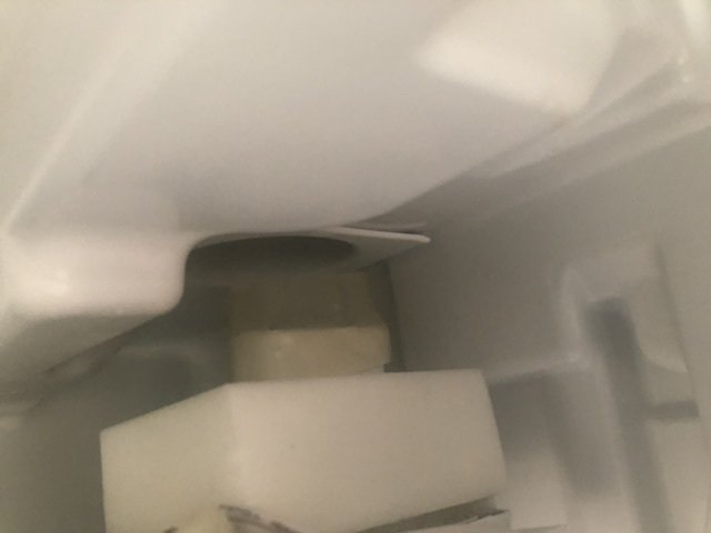 Kylskåps inre med isbildning runt ventilationsdelar och fråga om gummiringens korrekta placering.