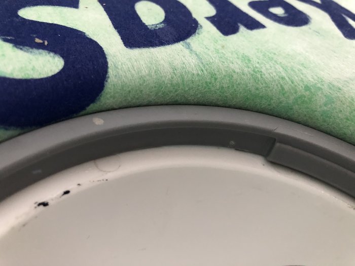 Närbild på en del av en kaklad vägg med en synlig stor fog ovanför en dörrkarm.