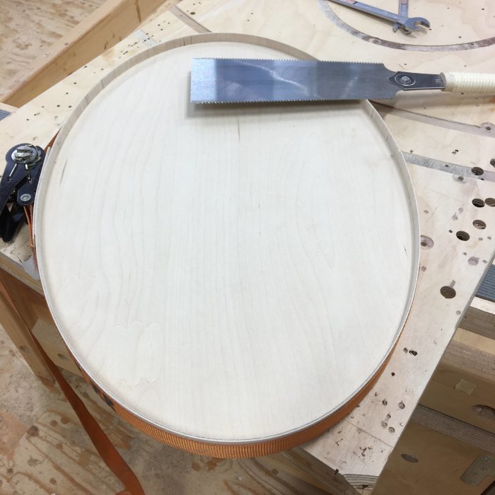 Oval bricka i björkplywood under tillverkning, med kantband och japansåg ovanpå.