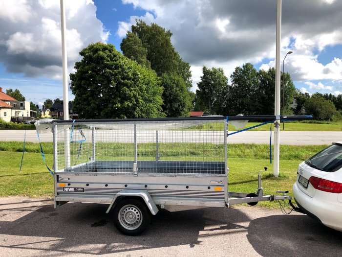 Lång takränna fastsatt ovanpå en släpvagn parkerad vid sidan av en väg på dagtid.