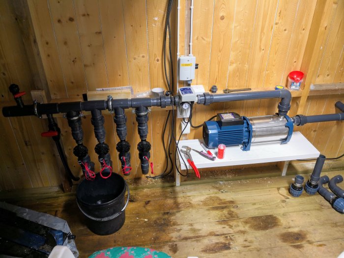 Bevattningsanläggning med Plurijetpump, tryckkontroller och rörledning i ett pumpskåp.