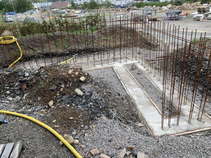 Gjutet fundament med armeringsjärn och bottenplatta för blomlåda och utekök under konstruktion.