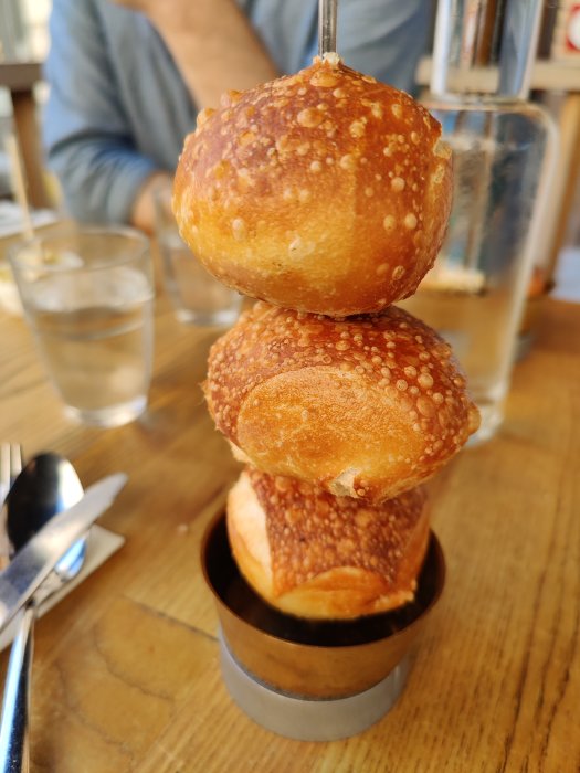 Tre frallor staplade på en metallstång på ett restaurangbord.