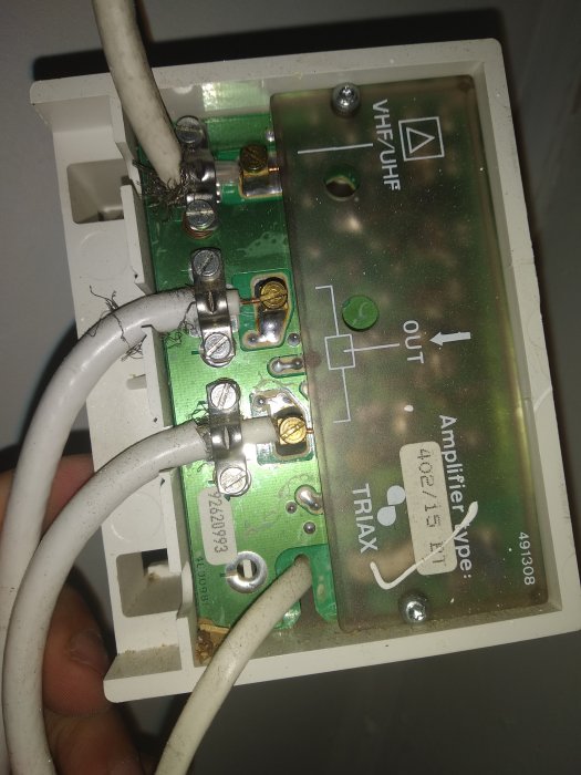 Elkablar anslutna till skruvklämmor på en antennförstärkarens kretskort markerat "TRIAX".