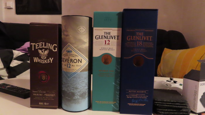 Fyra flaskor whiskey i förpackningar på rad: Teeling, Deveron, Glenlivet 12 och Glenlivet 18.