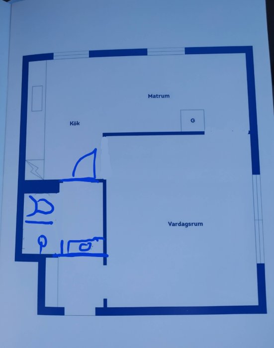 Ritning av en lägenhetsplan med markerade utrymmen för kök, vardagsrum och matrum samt en skissad dusch och tvättmaskin.