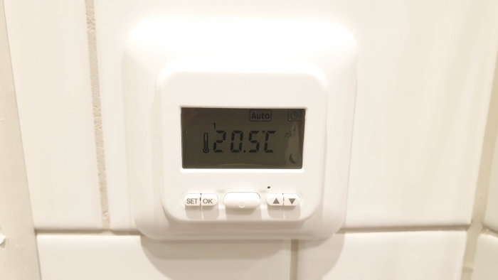 Vit digital termostat monterad på vägg utan synliga märken eller produktnamn, visar 20.5°C.