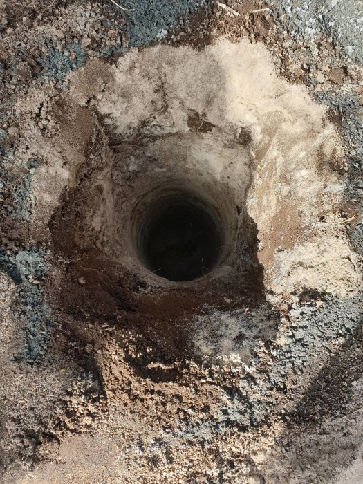 Top-down view of a 200mm wide borehole for a well, showing soil layers with 40cm of earth and sand below.