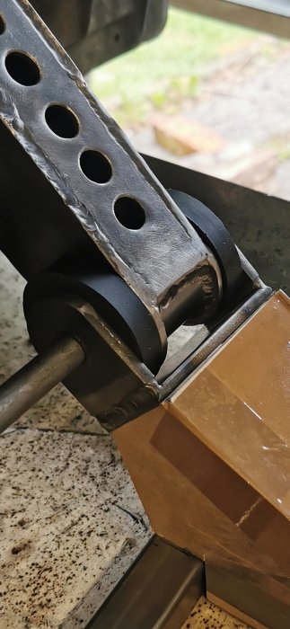 Metalfläns formad som ett U i 5 mm tjockt plattjärn fäst vid en metallstruktur med runda hål.