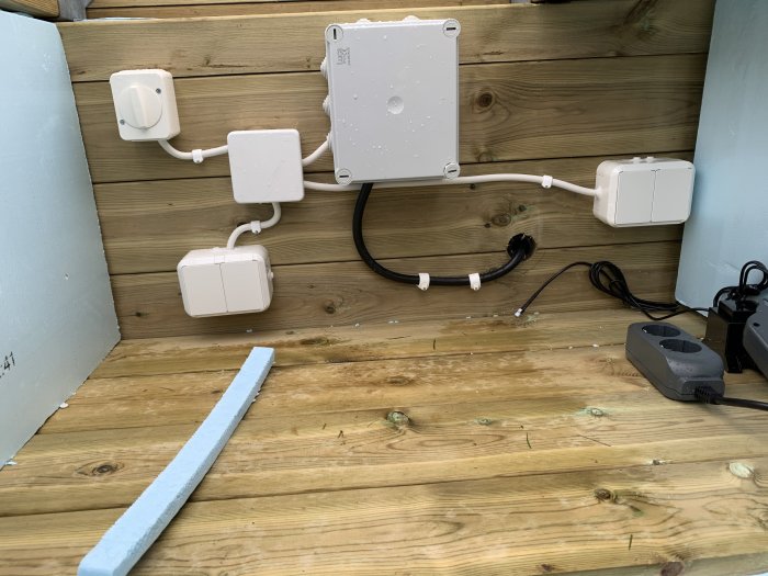 Elinstallation för terasspool med IP44-uttag och säkringar monterade på trävägg och isoleringsskivor på golv.