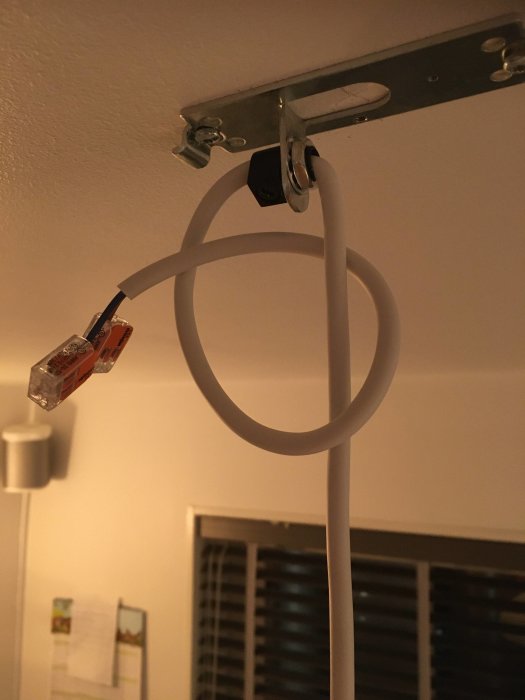 Ett Ethernet-kabelskarv skyddat av ett plasthölje monterat på en vägg med kabelklämmor.