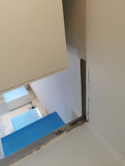 Elexponerat hörn med synliga kablar vid riven dörrpost.