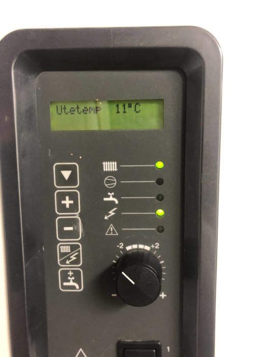 Digital värmepumpsregulator med en display som visar utetemperatur 11°C och justeringsknappar.