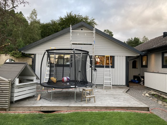 Nyinstallerade vindskivor på en nyrenoverad villa, med en studsmatta och ett lekhus i förgrunden.