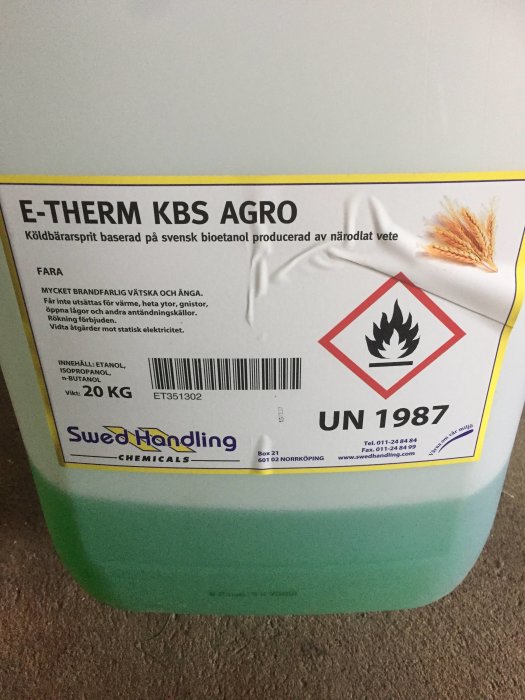 En dunk märkt 'E-THERM KBS AGRO', köldbärarsprit baserad på svensk bioetanol, framför en matta.