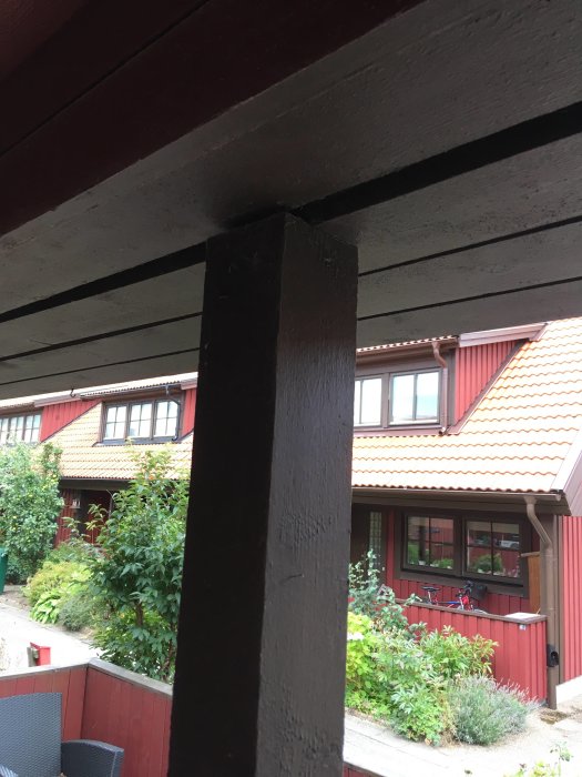 Ulkopilari, joka on kiinnitetty talon katon paneeliin ja ympäröity punaisella puuverhouksella. Pilarin mahdollinen tukevuus kyseenalaistetaan.