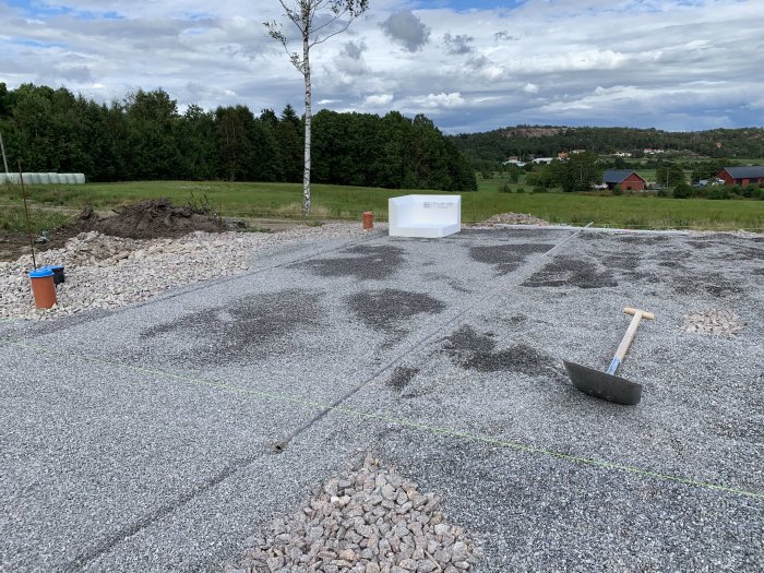 Ren grusyta med markeringslinjer och spade efter borttagning av flis.