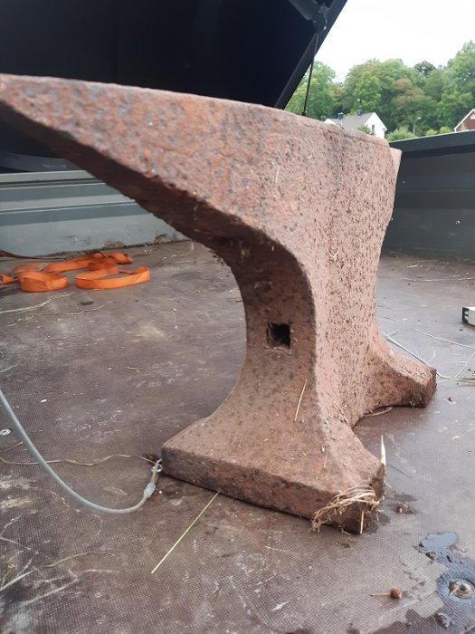 Närbild på äldre städ med rost och synlig skada, möjligen Söderfors, med hål i sidan.