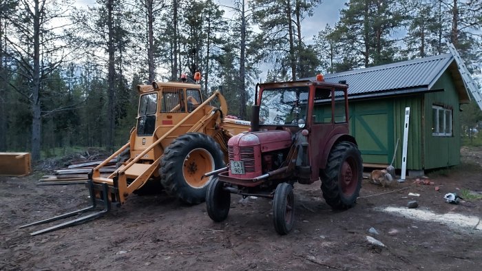 Gammal Bm Victor traktor med hytt från en David Brown och en gaffeltruck i ett skogsområde vid skymning.