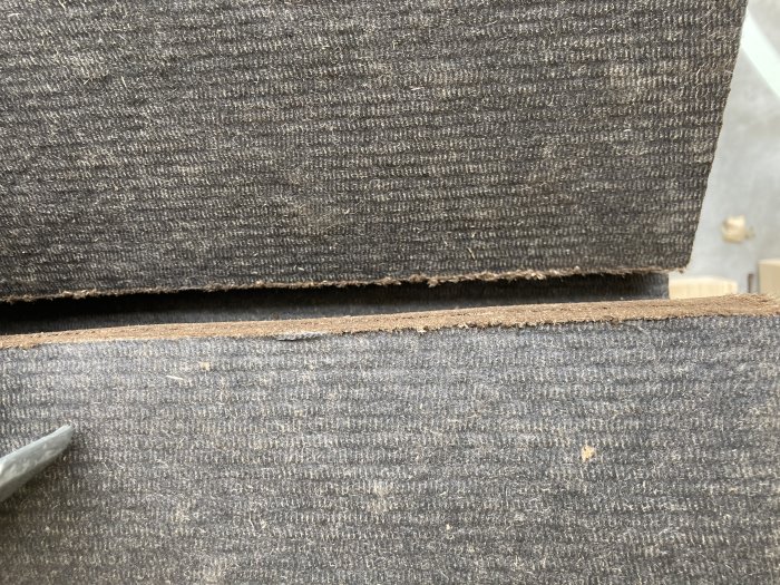 Slipad kant på en asfaboard närbild där panelbitarna möts, fina skarvar efter sågning.