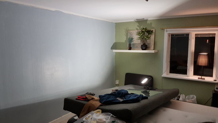 Sovrum under renovering med blå och grön vägg, ny garderobslösning, golv och arbetsbelysning.