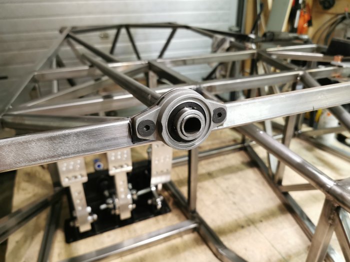 Första delen av ett rattstångsbygge, ett kullager monterat i en metallarm med en stålkonstruktion i bakgrunden.