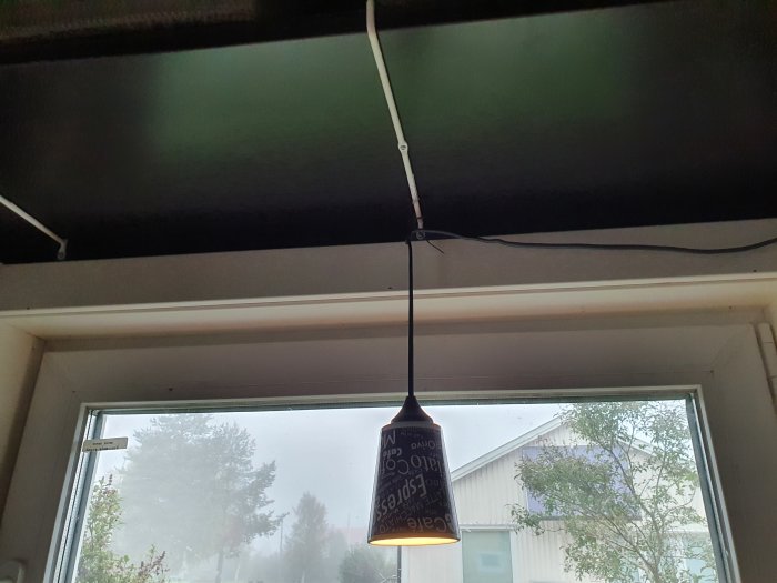 Fönster med en hängande lampa och rullgardin där rammen ser trång ut för ventilinstallation.