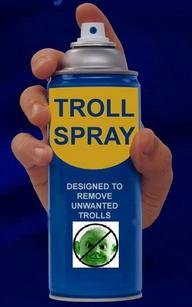 En hand håller en sprayburk märkt "TROLL SPRAY" avsedd för att ta bort oönskade troll.