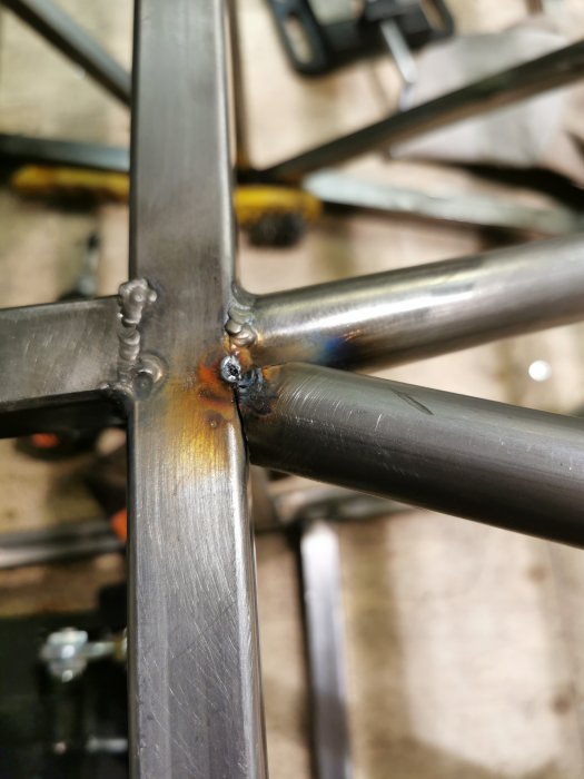 Svetsning på metallkonstruktion med synlig svetsfog och värmeutstrålning som indikerar nyligen arbete.