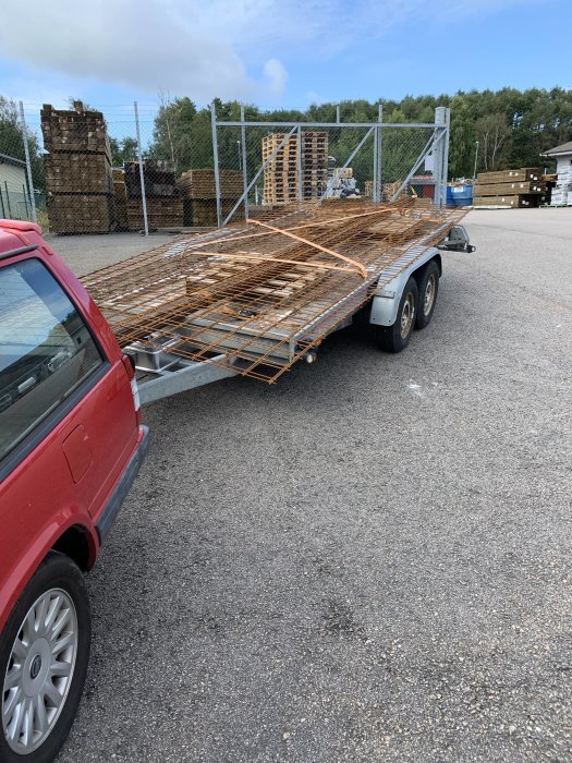 Armeringsjärn på släpvagn parkerad vid byggmateriallager.