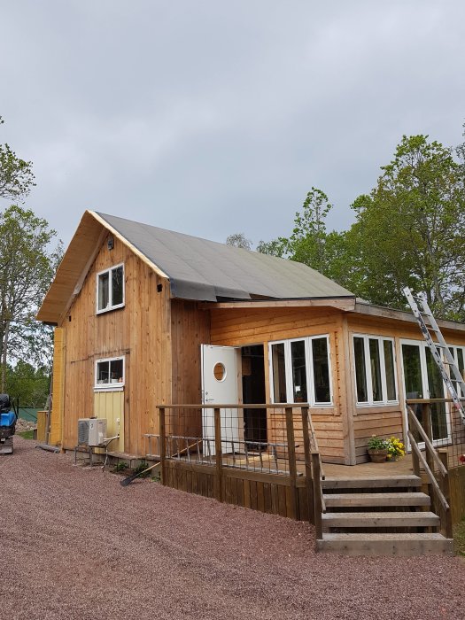 En ombyggd gammal sommarstuga från 1958 med träfasad och nytt tak under inbyggnation.