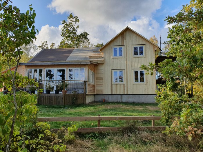 Hus under renovering med ny liggande fasadpanel på sidor och stående panel på gavlar.