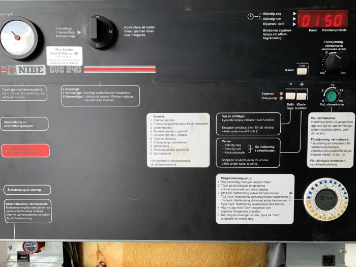 Kontrollpanel för NIBE värmepanna med inställningsrattar, digital temperaturdisplay och instruktionsetiketter.