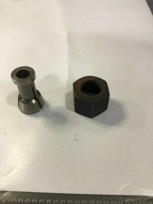 28mm lång metallhylsa bredvid en kub med 8mm hål, båda på ett vitt bord.