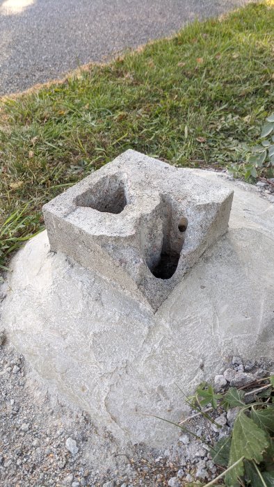 Betongplint med utborrade hål och en skadad sida redo för reparation och gjutning.