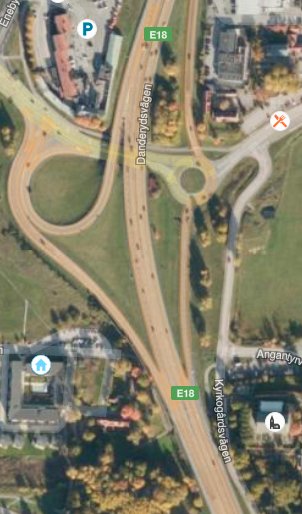 Flygfoto över E18 med trafikplats och avfarter nära Bergshamra, illustrerar diskussion om körfält.