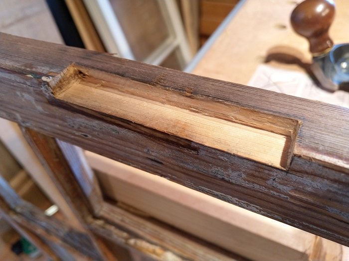 Renoverat fönsterbåge med nytt trä insatt för att reparera en spricka.