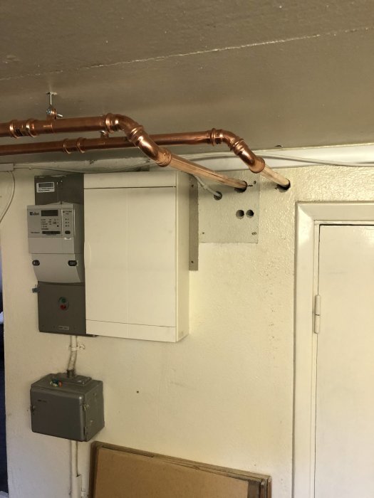 Nya kopparledningar för tappvatteninstallation monterade längs tak i ett tekniskt utrymme.