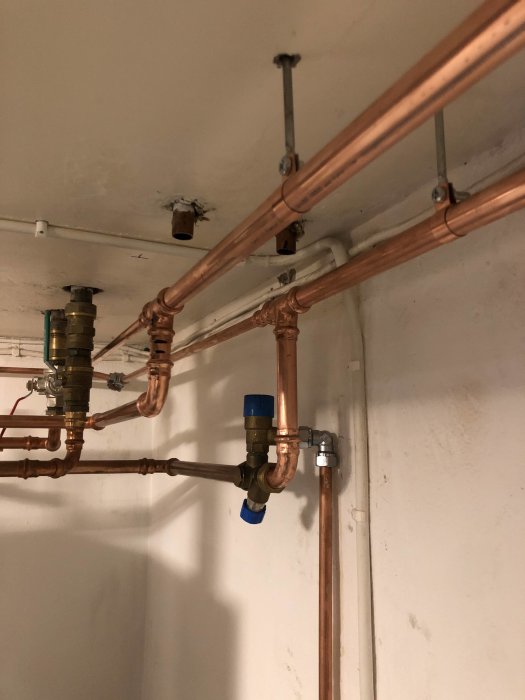 Nya kopparledningar och fördelare för tappvatten i en villa, med fokus på en nyligen åtgärdad läcka.