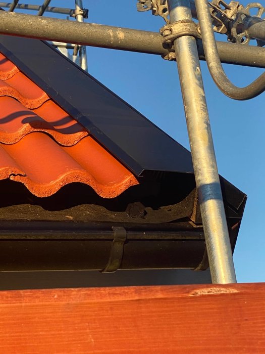 Närbild på takkanten med stort gap mellan vidskiva och takpanna, potentiell risk för fågelbon.