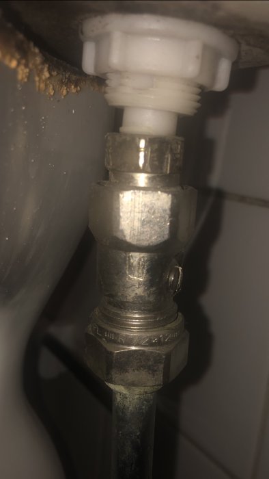 Närbild av en gammal Mora vattenkoppling med en eventuell avstängningsventil till toalett.