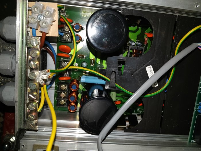Interiör av elektrisk apparat med kablar och komponenter, installationsdetaljer synliga.