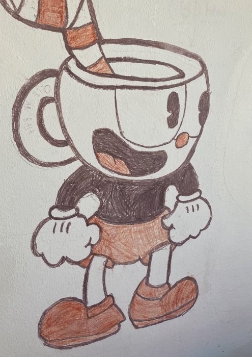 Barnritning av animerad koppfigur på vägg målad med spritpennor.