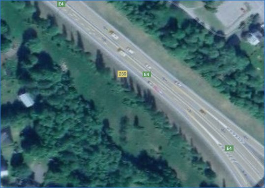 Satellitbild över en vägkorsning där E4 går från enfilig till tvåfilig med väg 239 anslutande.