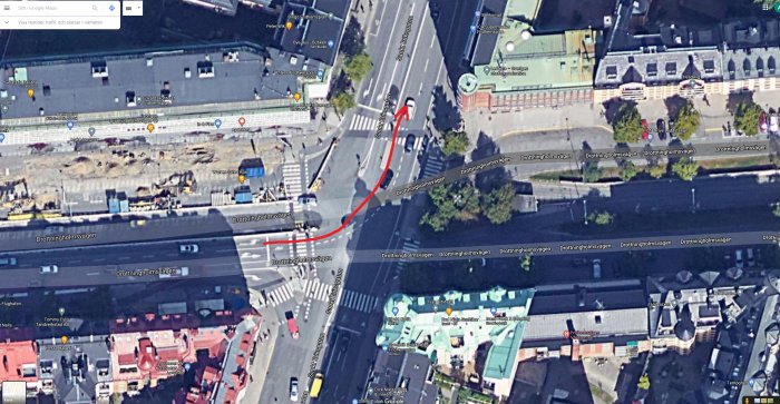Satellitbild på en vägkorsning med ett överlagrat rött streck som visar en bilbana som svänger vänster.