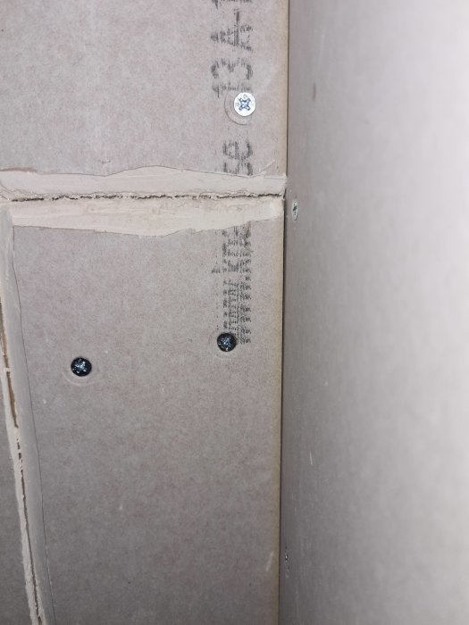 Vertikal skarv mellan två gipsskivor där vänster är manuellt skuren med fasning och höger har fabriksfasning.