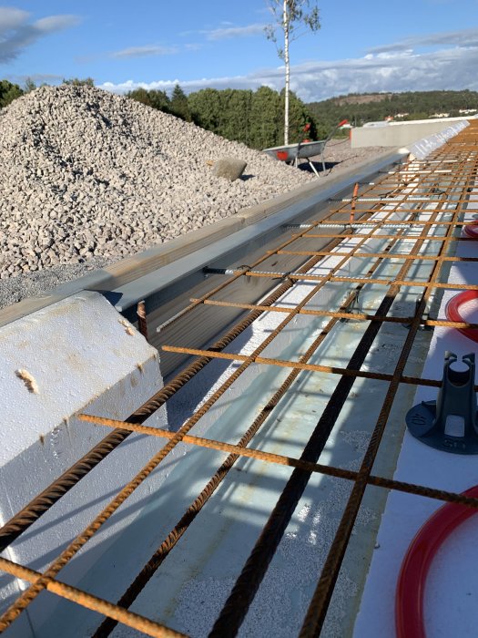 Förberedelse för gjutning med armeringsjärn, termoelement och grus i bakgrunden.