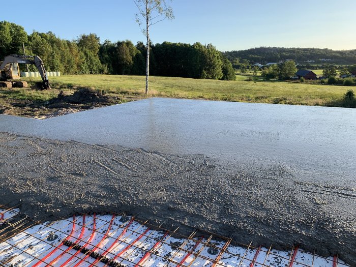 Nyligen gjuten betongplatta med armeringsjärn och landsbygd i bakgrunden.