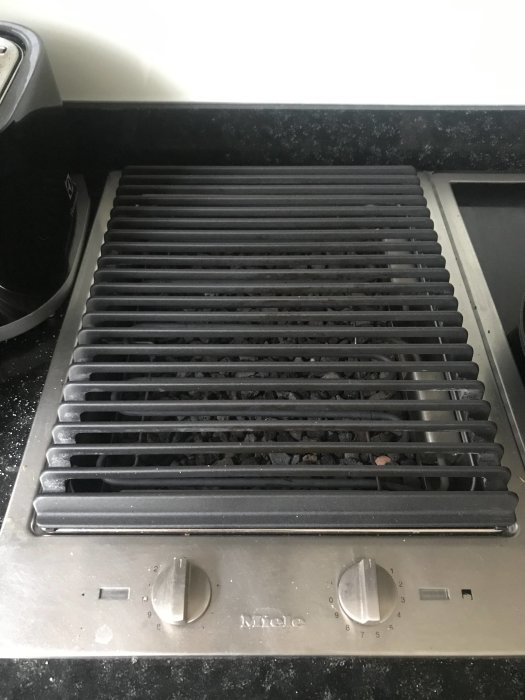 Miele cs1322Bg grillhäll i ett kök, med synliga lava stenar och reglage.